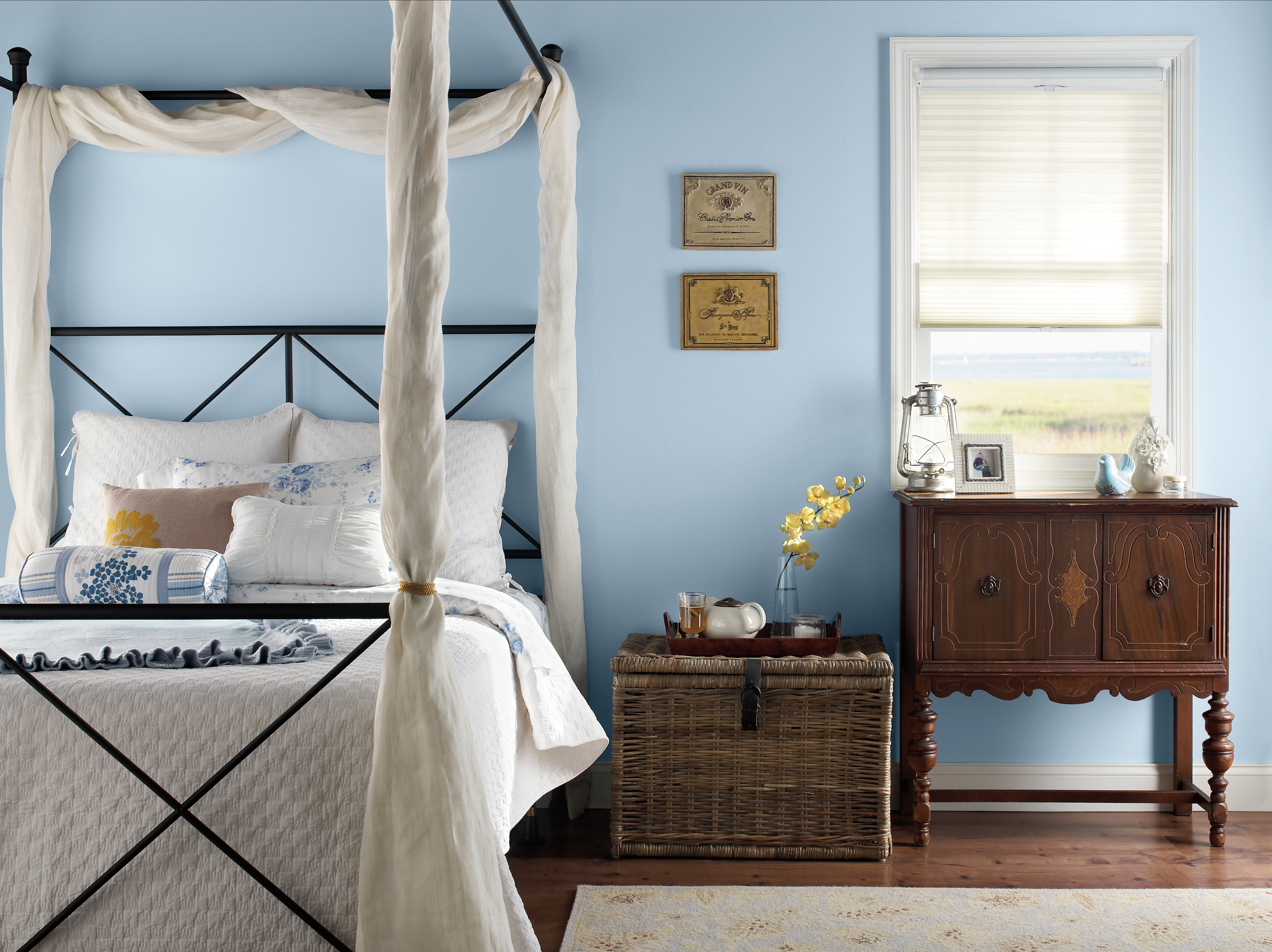 Alt Text: Cette image montre une chambre à coucher au décor serein, incluant un mur bleu pastel en teinte Lumière céleste (MQ3-24), une délicate literie blanche et de chauds accents de matériaux naturels.