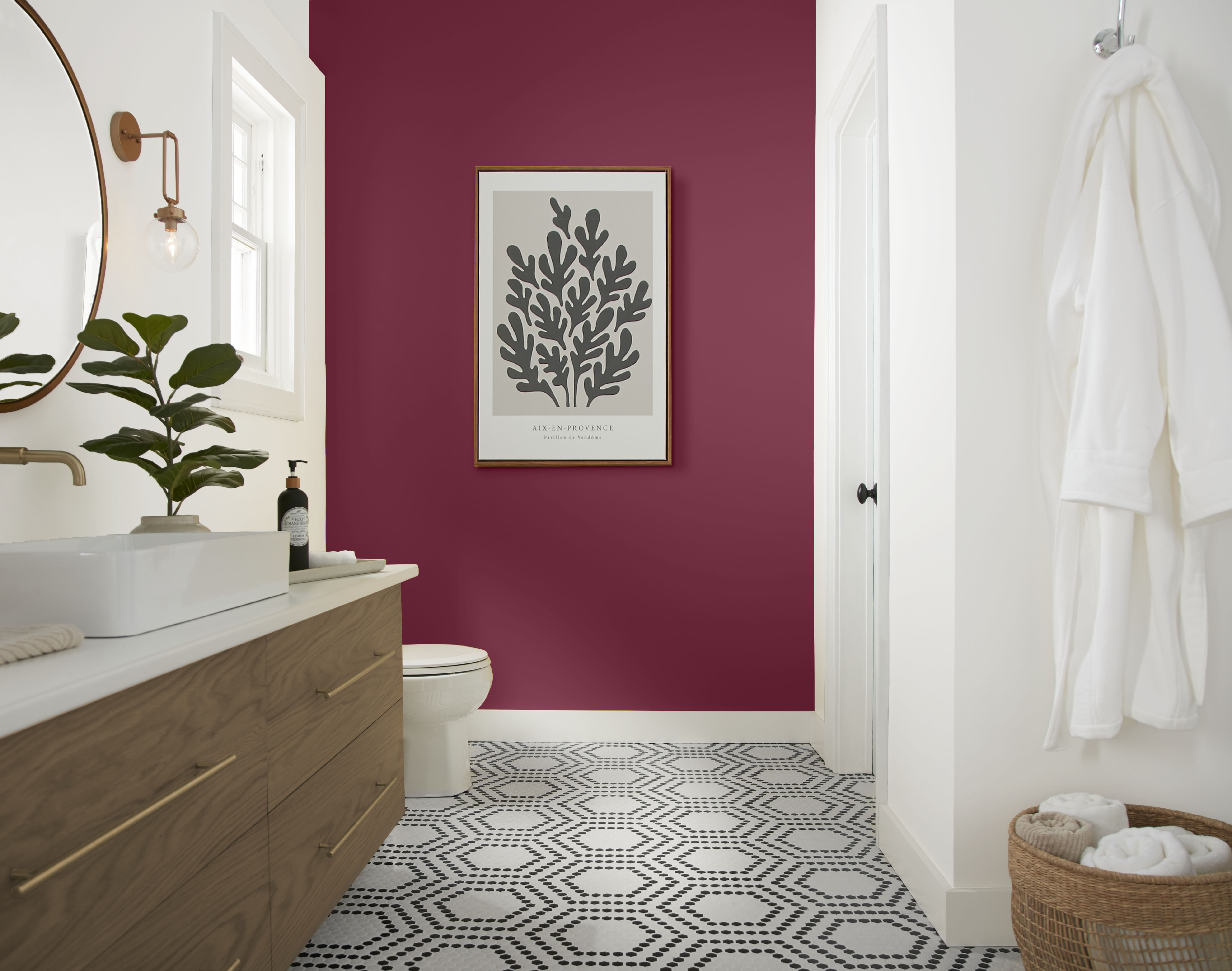 Cette image montre une salle de bain avec un mur d’accent pourpre peint en teinte Betterave sucrée, des moulures blanches, un meuble-lavabo en bois, un carrelage à motifs noir et blanc au sol et un style apaisant qui rappelle l’ambiance d’un spa.