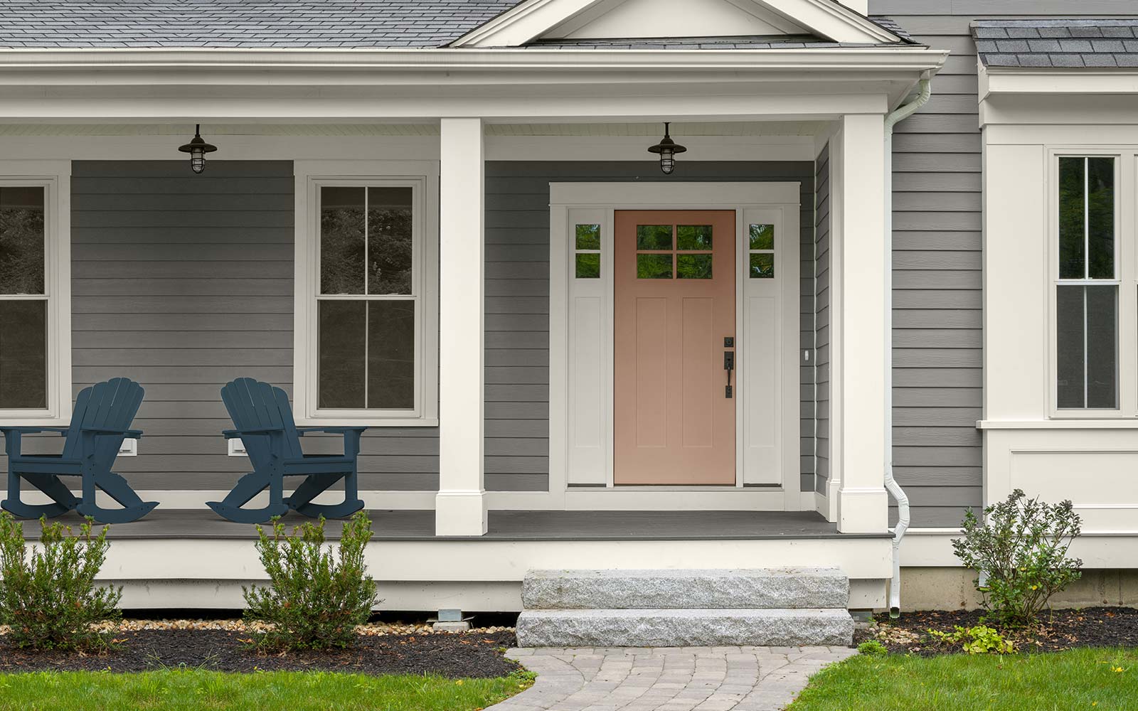 An exterior image with four color swatches sitting beside it. The image displays the four colors: a medium gray hue for the exterior body, a dark blue hue for the chair sitting on the porch, a dusty orange hue is used on the door, and a creamy white hue is used for the exteriors trim.