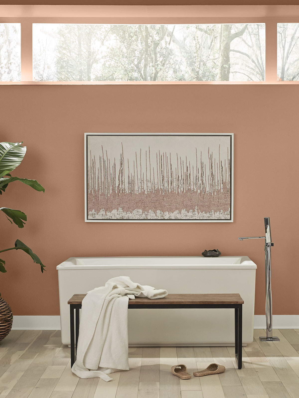 A bathroom showing a white tub and wood bench placed against a tall painted wall in the color Canyon Dusk.