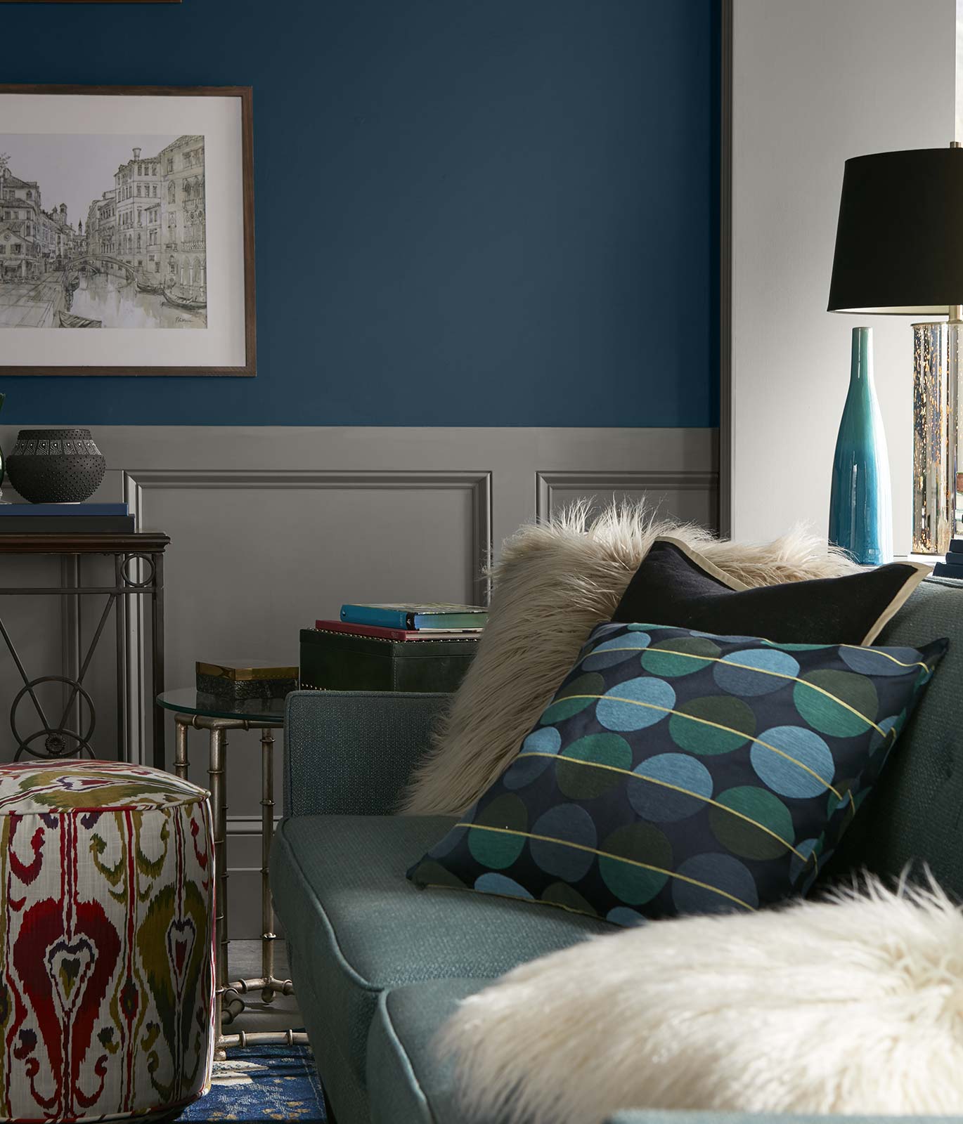 A tight crop of a living room with a light blue couch and darker blue painted walls. The mood is quiet and relaxed.